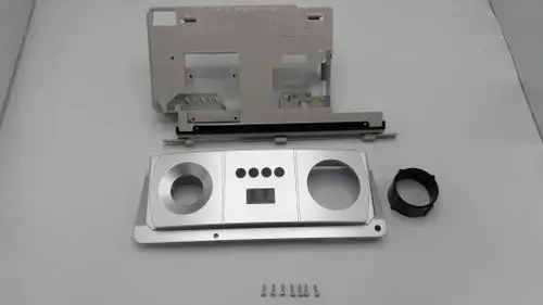 Vorderteil eines Schaltfeldes von Remeha, bestehend aus mehreren Metall- und Kunststoffteilen, darunter eine Grundplatte mit Ausschnitten und Bedienelementen.